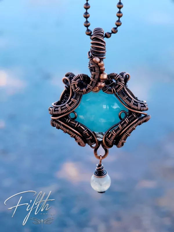 Smithsonite fifth energy copper jewelry against sky reflecting in water