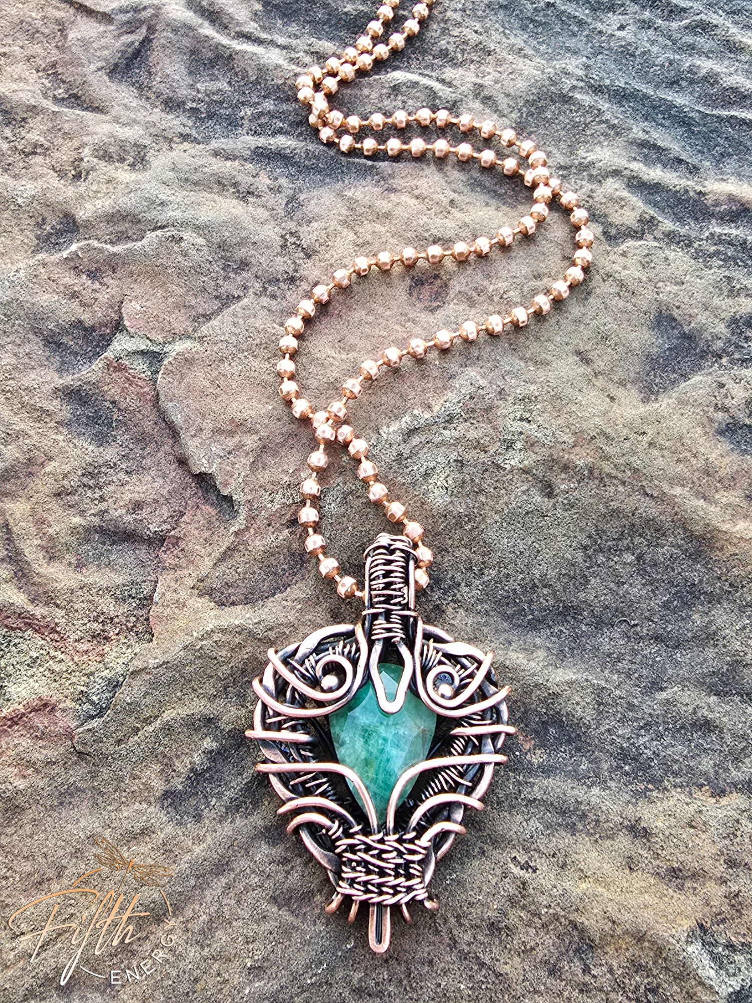 Copper Encased Emerald Necklace 3 A one-of-a-kind emerald necklace handcrafted in the USA, featuring a natural emerald gemstone encased in polished American-made copper. The artisan design showcases unique wirework and sustainable materials.