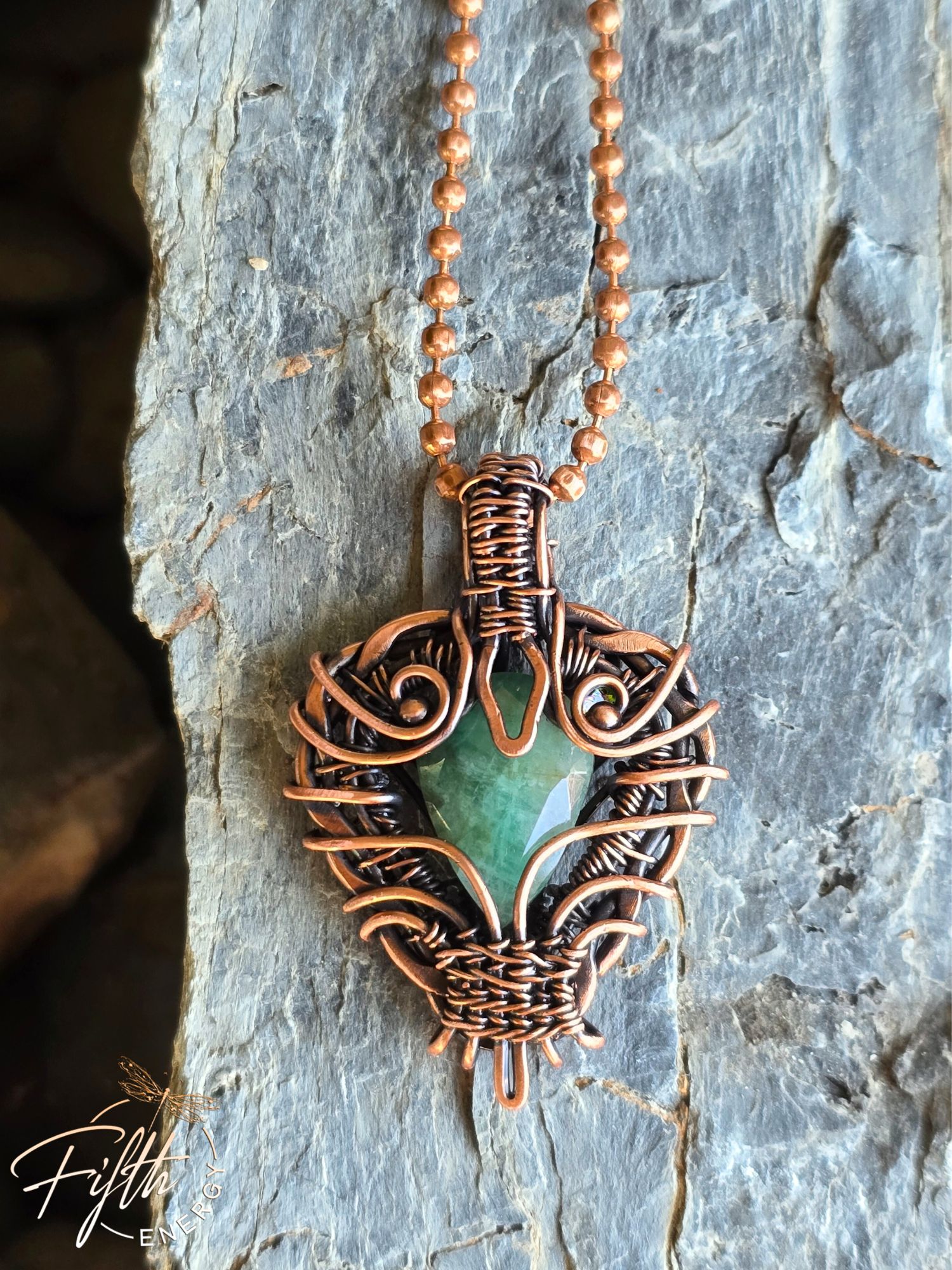 Copper Encased Emerald Necklace 8 Handmade USA-made emerald pendant necklace featuring a raw emerald stone secured in American-made copper. The rustic, artisanal wrap design makes this piece a unique gift for gemstone and copper jewelry collectors.