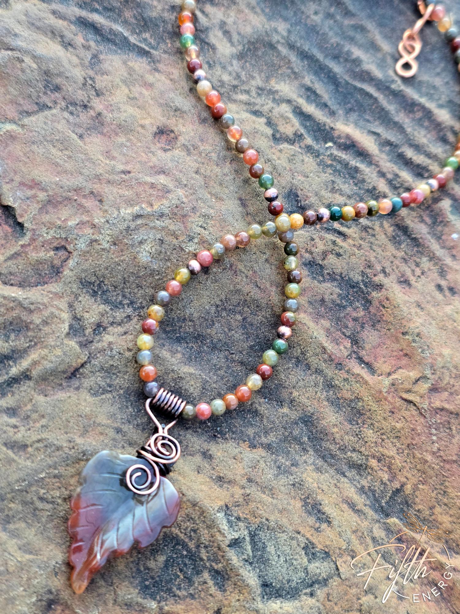 Warm Indian Agate Carved Leaf Necklace 5 Close-up of Indian Agate leaf pendant showcasing natural warm earth tones and handcrafted copper bail on an artisan beaded necklace.