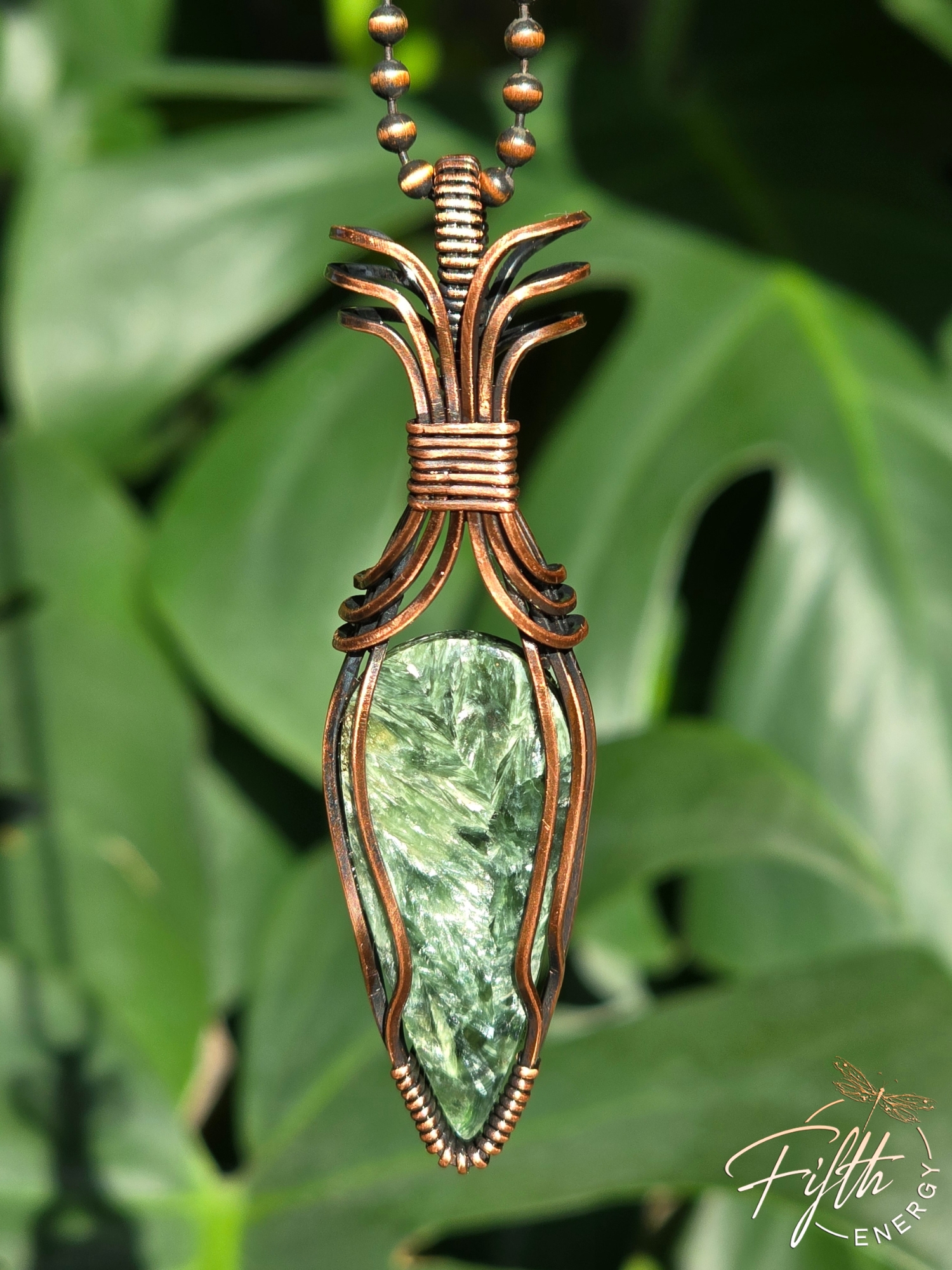 Elevate your look with a Seraphinite Necklace from Fifth Energy Jewelry, glowing with deep green shimmer and handcrafted copper artistry.